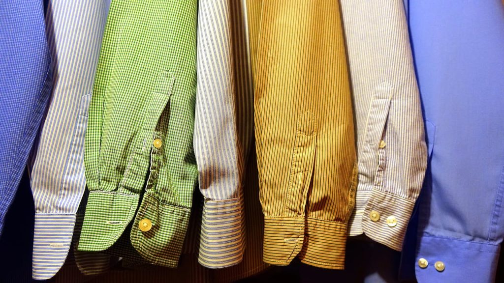 A row of vibrant, striped shirts hanging neatly, showcasing fashion variety.